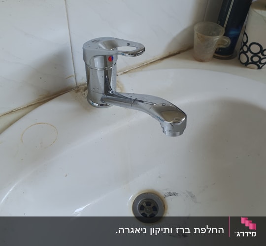 ברז כרום בכיור עם כתמי לכלוך